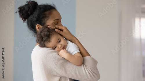 Konstfotografi Caring young biracial mother hold lean to chest cute little infant toddler, lovi