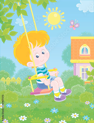 Cheerful small boy swinging with a merry flittering butterfly in a pretty green yard of a summer house in a village on a sunny warm day, vector cartoon illustration