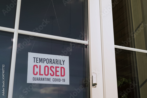 TEMPORARILY CLOSED sign on a door shop, restourant. Small business sign on the storefront window closed because of coronavirus or COVID19.