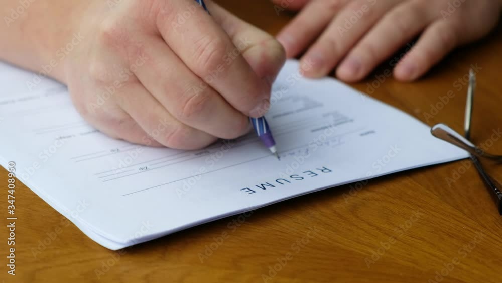 Somebody filling a RESUME form, applying for job. Close up Somebody filling a RESUME form, applying for job. Close up