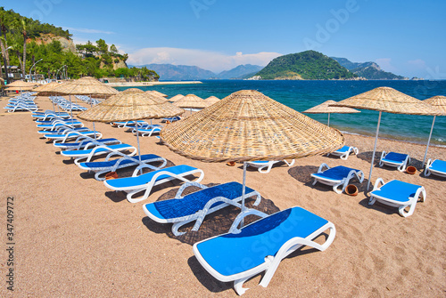 Fototapeta Naklejka Na Ścianę i Meble -  sandy beach without people and with sun loungers, umbrellas, palm trees, Marmaris
