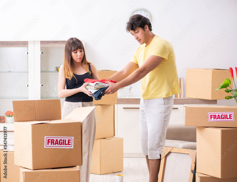 Young couple moving to new flat with fragile things Young couple moving to new flat with fragile things