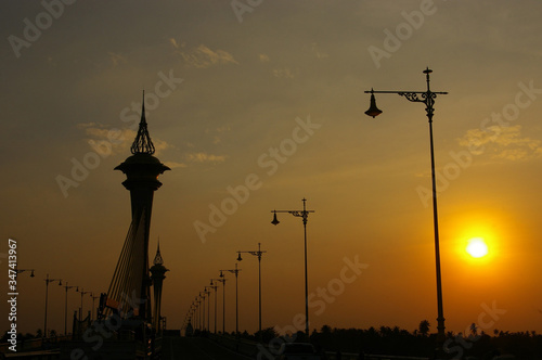 sunset at maha chedsadabodindranusorn bridge , the crown and lototus at the top of pylon