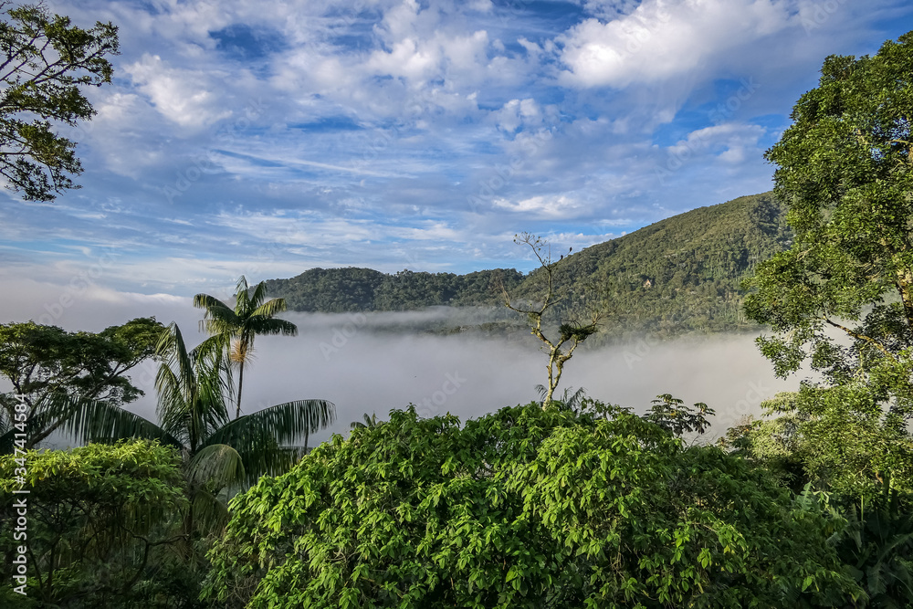 Wonderful view to Atlantic forest mountains, valley covered with fog and blue sky with white clouds in background, Itatiaia, Rio de Janeiro, Brazil
