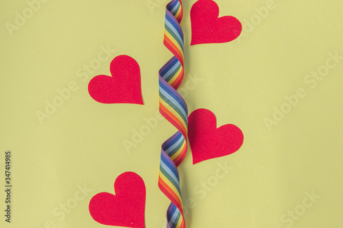 Red paper hearts with rainbow ribbon on a yellow background. thanks to the medical staff for their work photo