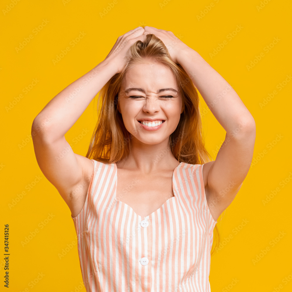 Funny Teen Girl Grimacing And Touching Her Hair Over Yellow Background Funny Teen Girl Grimacing And Touching Her Hair Over Yellow Background