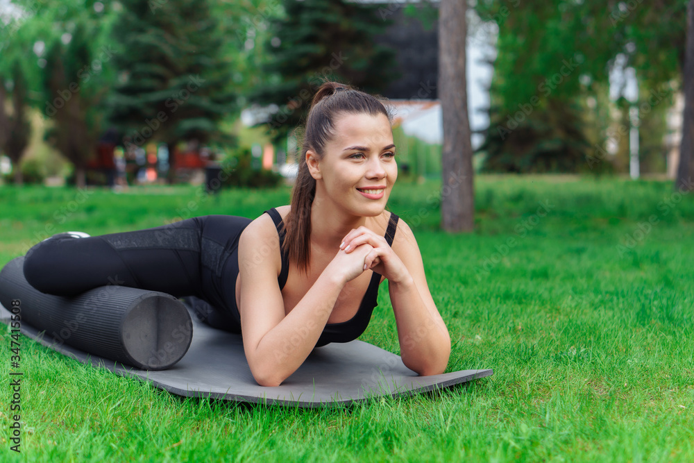 Woman doing foam roller exercise in park