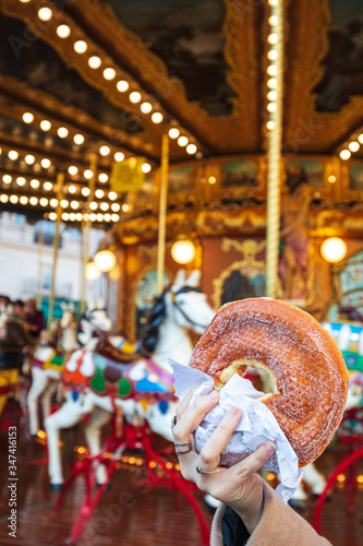 Photography A sugary donut in front of an ancient German Horse Carousel built in 1896 in Nav