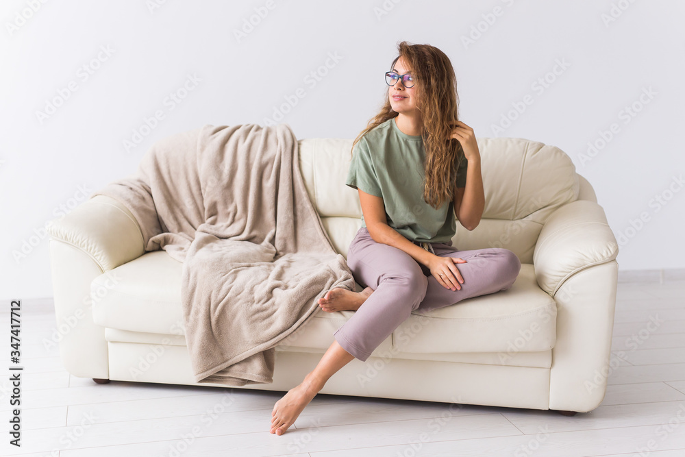 Coronavirus, Covid-19, Quarantine, isolation, coronavirus pandemic world. Stay at home. Pensive woman spending time sitting on sofa at home.