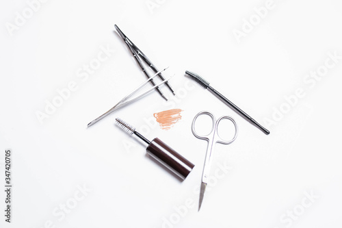 Makeup brushes, scissors, tweezers, mascara on a white background. Makeup. Beauty and fashion.