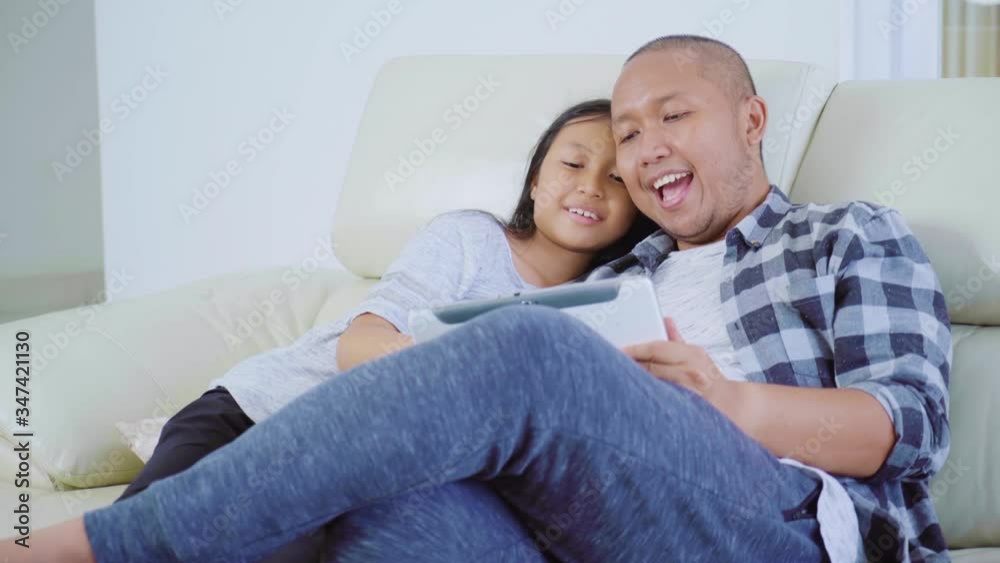 Little girl and her father using a tablet at home Little girl and her father using a tablet at home