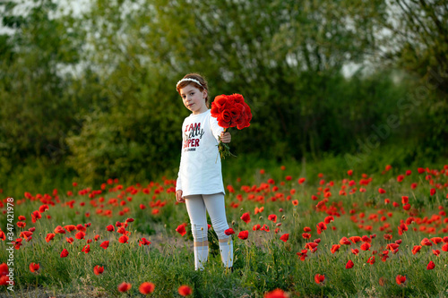 Bambina con fiori di papaveri su sfondo di natura per cataloghi di moda, fashion, riviste, copertina, pubblicità e messaggi commerciali photo