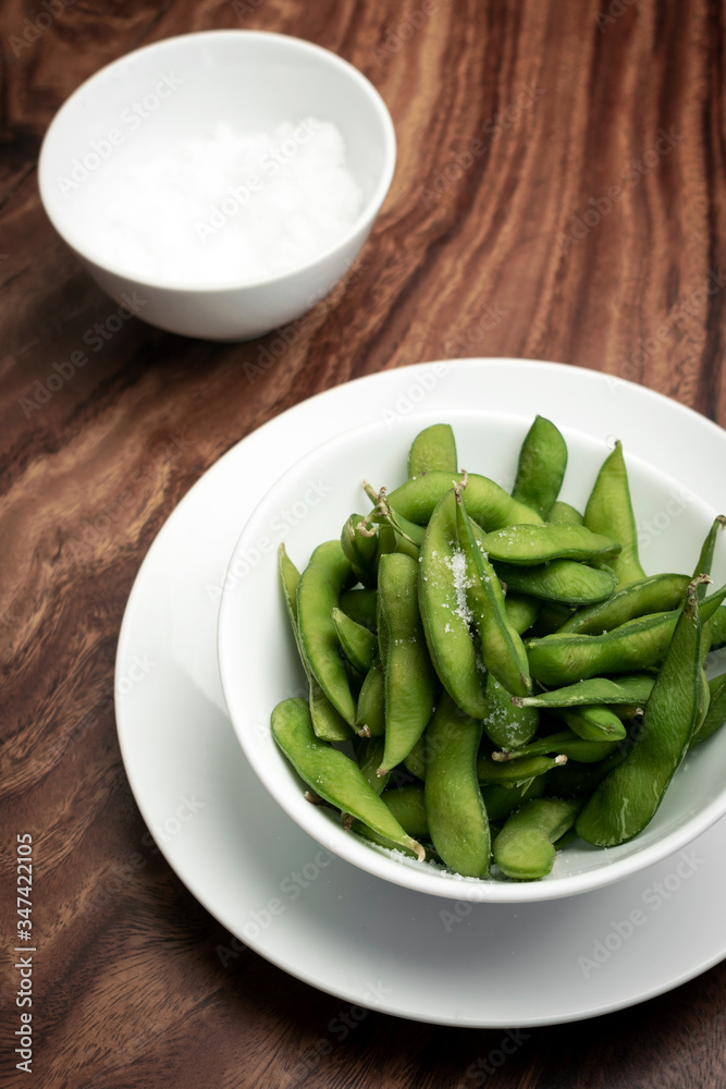 edamame beans snack in bowl on table with sea salt edamame beans snack in bowl on table with sea salt