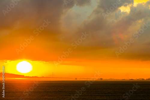 Sunset on the field. Beautiful sunset landscape with large field and a forest on background