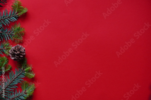 Christmas decorations layout or flatlay with fir branches and cones on red background.Eco natural frame. winter  new year Holidays concept as top view  copyspace. greeting card template  banner mockup