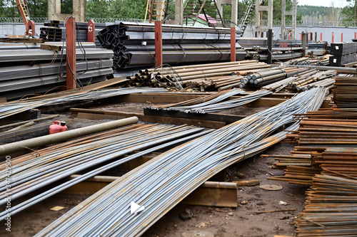 Photo of black metal lay in stacks of pallets outdoors