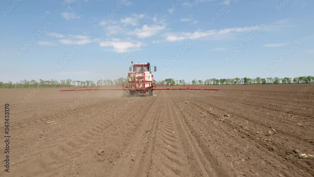 Flying behind tractor while sprays in a field Flying behind tractor while sprays in a field