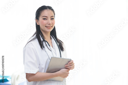 portrait of doctor woman smiling holding tablet working at office in hospital.