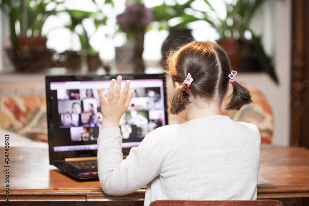 Study online with video call teacher. Young girl learn online and looking at laptop at home.Social distancing. Study online with video call teacher. Young girl learn online and looking at laptop at home.Social distancing.