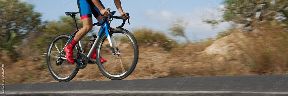 Road bike cyclist man cycling, athlete on a race cycle. Panning technique used Road bike cyclist man cycling, athlete on a race cycle. Panning technique used