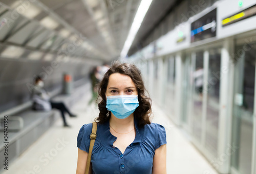 Brunette in medical mask waiting for subway train