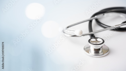 Black stethoscope for doctor diagnosis coronavirus disease, medical tool for healthcare on blue background with copy space