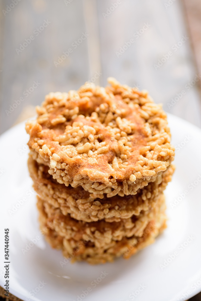 Stack of deep fried sweet crispy rice with cane sugar drizzle on white plate, Local Thai snack (Khao Tan) Stack of deep fried sweet crispy rice with cane sugar drizzle on white plate, Local Thai snack (Khao Tan)