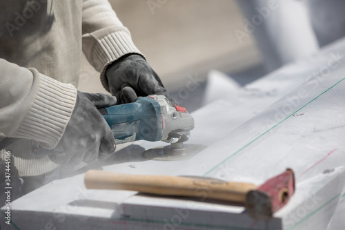 sculptor cutting marble with grinder