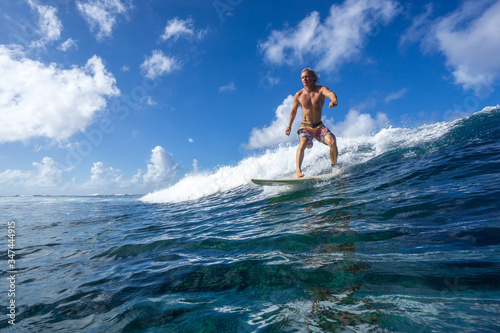 muscular surfer riding on big waves on the Indian Ocean island of Mauritius © ohrim