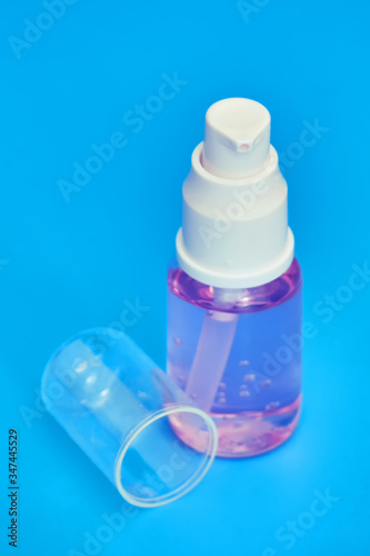 Medical hand sanitizer with bottle cap on blue background, spray closeup. Coronavirus quarantine face cleanser