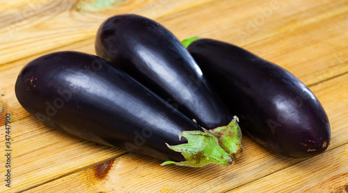 Fresh eggplants  on wooden surface in home kitchen