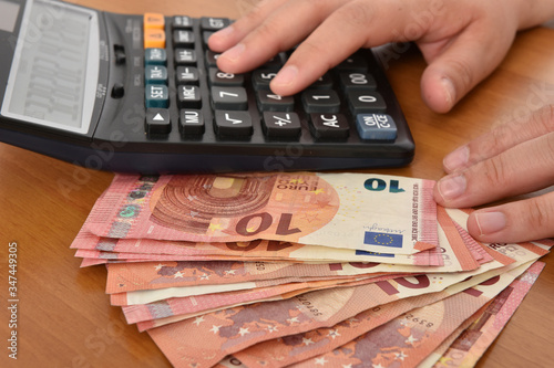 Close-up of a calculator and 10 euros bills symbolizing the concept of economy and bill payement.