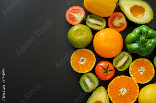 Many fruits and vegetables placed on the black background.  Plenty of vegetables and fruits and there s space to put text.