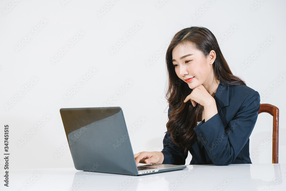 Successful girl manager in her own office makes a new economic development business plan on a laptop . A business woman with documents sits at a wooden table Successful girl manager in her own office makes a new economic development business plan on a laptop . A business woman with documents sits at a wooden table