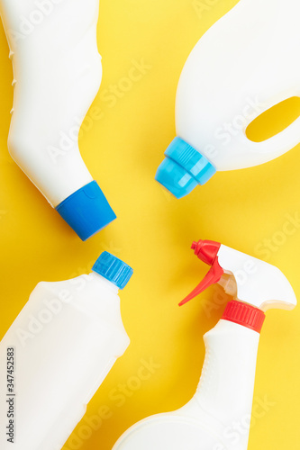 blank chemicals bottles on a bright yellow background. copy space. cleaning and washing concept.