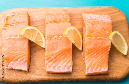 Delicious salmon steak on wooden cutting board, close-up.