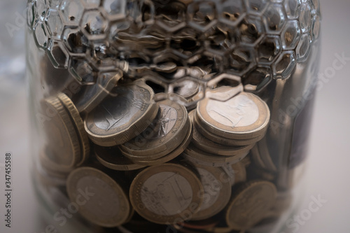 Monedas de euro dentro del bote de cristal