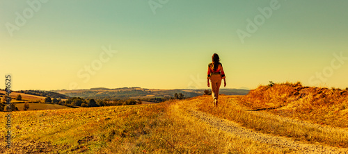 Frau beim Spaziergang auf einem Feldweg