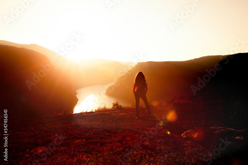 Silhouette einer Frau bei Sonnenuntergang am Aurlandsfjord
