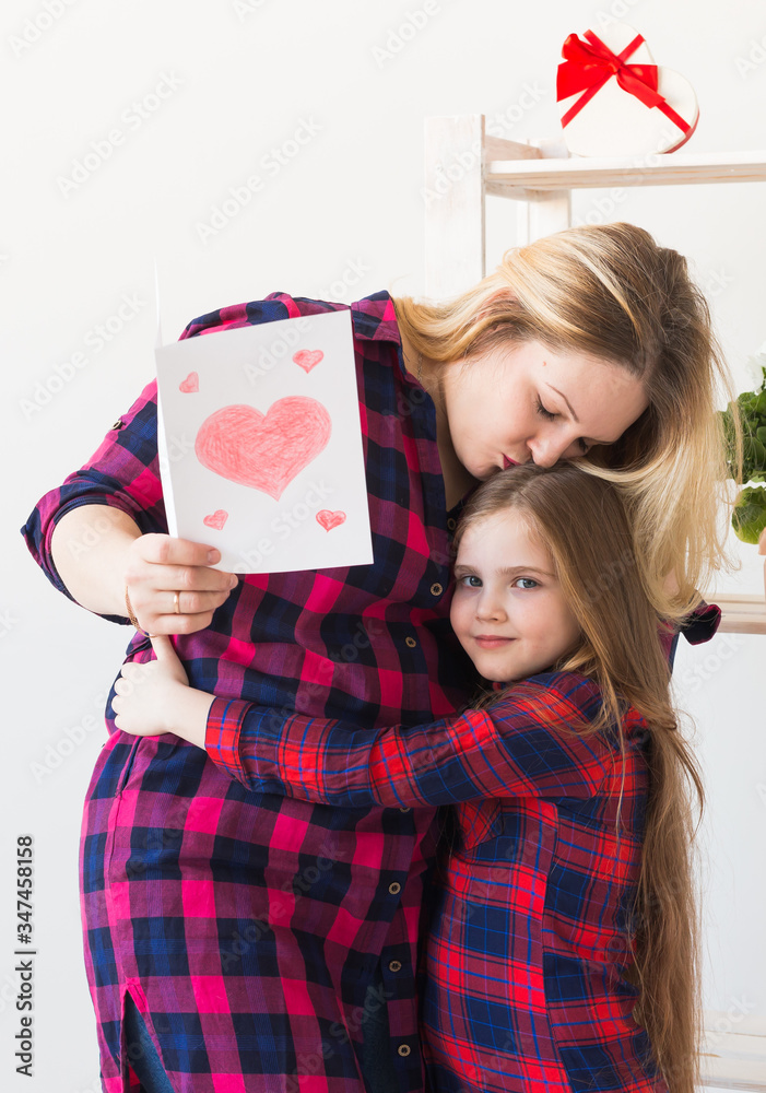 Mother's Day, holidays and family holidays - Mother holds greeting card from her lovely daughter. Mother's Day, holidays and family holidays - Mother holds greeting card from her lovely daughter.