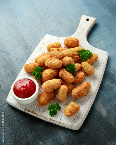 Crispy Battered scampi nuggets with ketchup on white wooden board photo