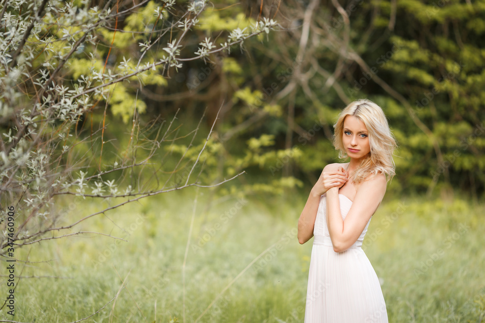 Blonde girl in a dress enjoys spring nature Blonde girl in a dress enjoys spring nature