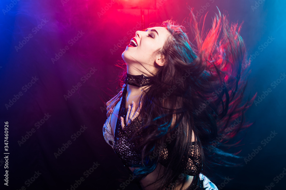 Young woman belly dancer in exotic dress with gold, dancing tribal fusion dance in studio. Young woman belly dancer in exotic dress with gold, dancing tribal fusion dance in studio.