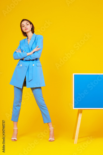 High fashion portrait of young elegant woman in blue suit.