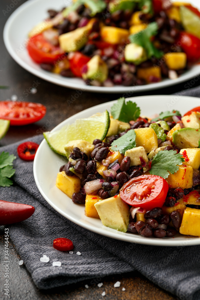 Avocado, mango salad with black bean on white plate Avocado, mango salad with black bean on white plate