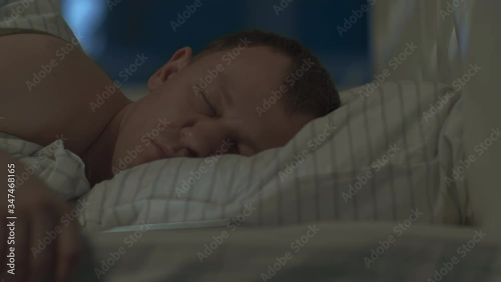 Young man woke up at night with a mobile phone Young man woke up at night with a mobile phone