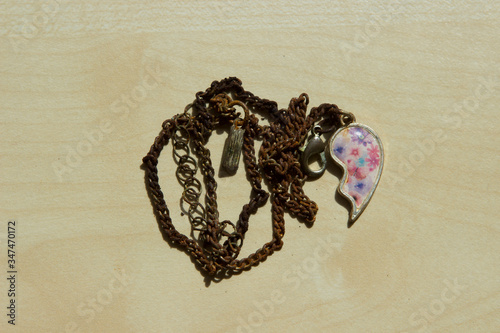 Quadro su tela rusted chain with a heart pendant is on the table