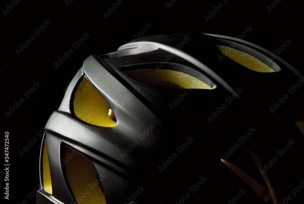 Helmet with yellow foam inserts. Black helmet on a dark background.