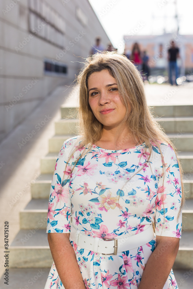 Naklejka premium Portrait of happy cheerful smiling young beautiful blond woman outdoor. Summer and people concept.