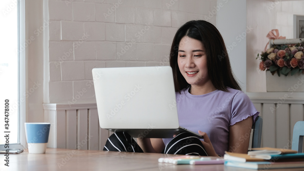 Asian young female student sitting at home, using laptop when studying online. Asian young female student sitting at home, using laptop when studying online.